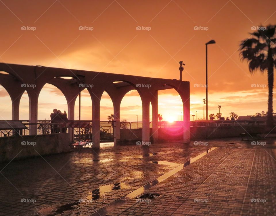 lovers taking a selfie at sunset golden hour. Civitavecchia