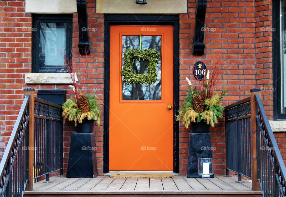 Orange front door with wreath