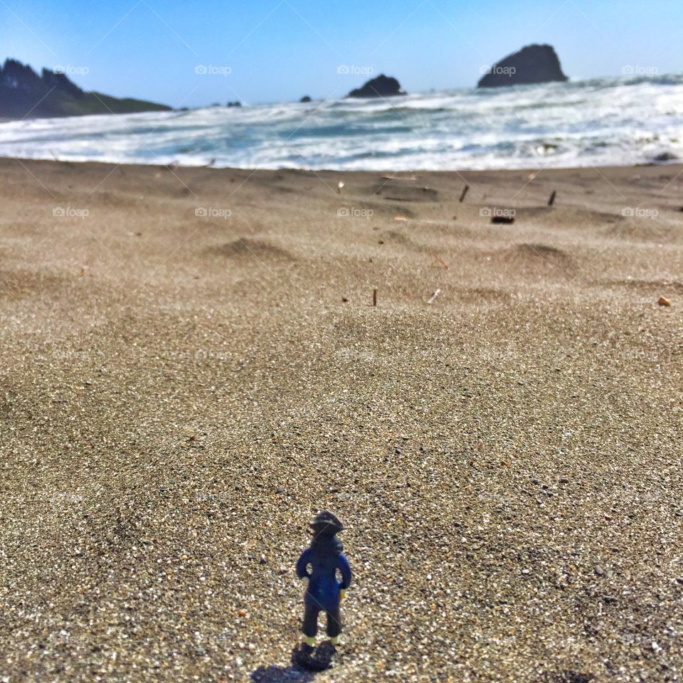 A pirate toy looking out at the Pacific Ocean. 