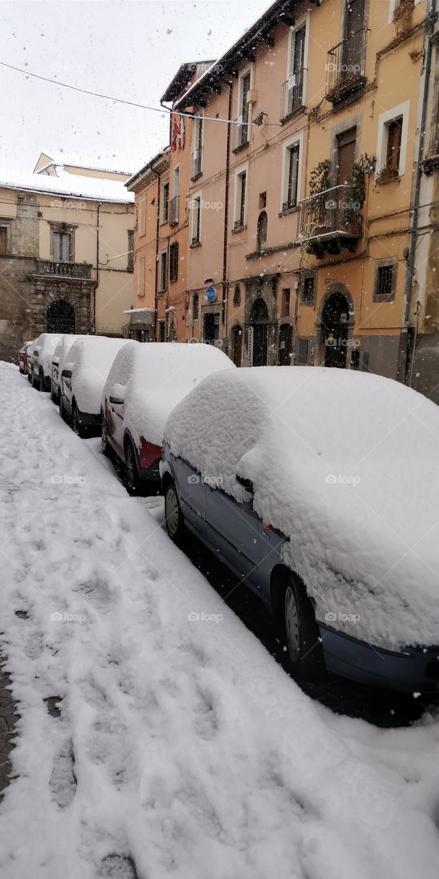 typical european street winter snow on cars