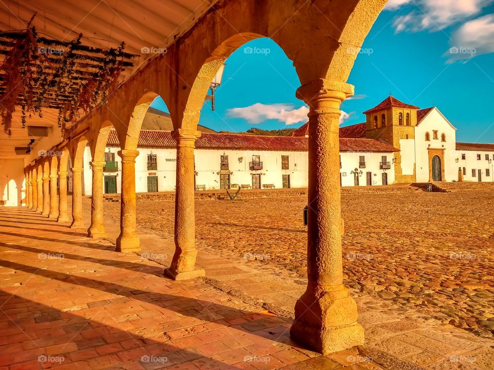 Arcos, columnas, sombras y contrastes en la plaza principal de Villa de Leyva Boyacá Colombia al atardecer. Arches, columns, shadows and contrasts in the main square of Villa de Leyva Boyacá Colombia at sunset. Horizontal