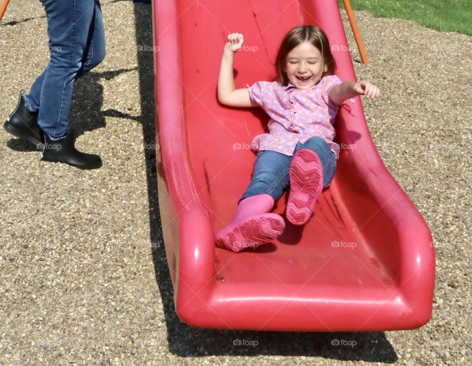 Girl sliding down sliding board 