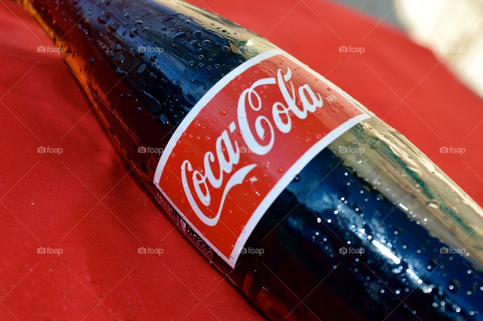 A bottle of Coca-Cola on a red background