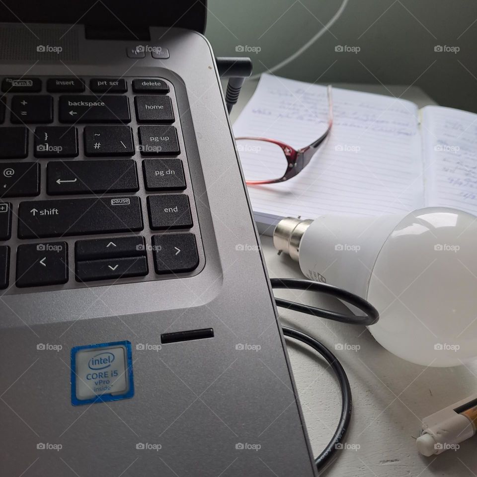 lightbulb moment with laptop keyboard desk glasses notebook. workdesk. work from home.