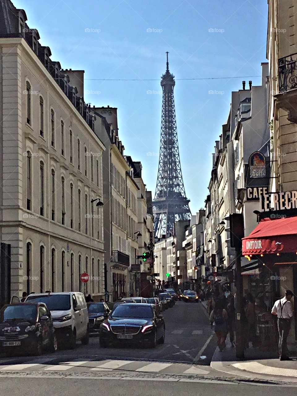 Cities and countrysides - Foap Missions - Busy and crowed city street lined with cars and people with the wrought-iron lattice tower in the background