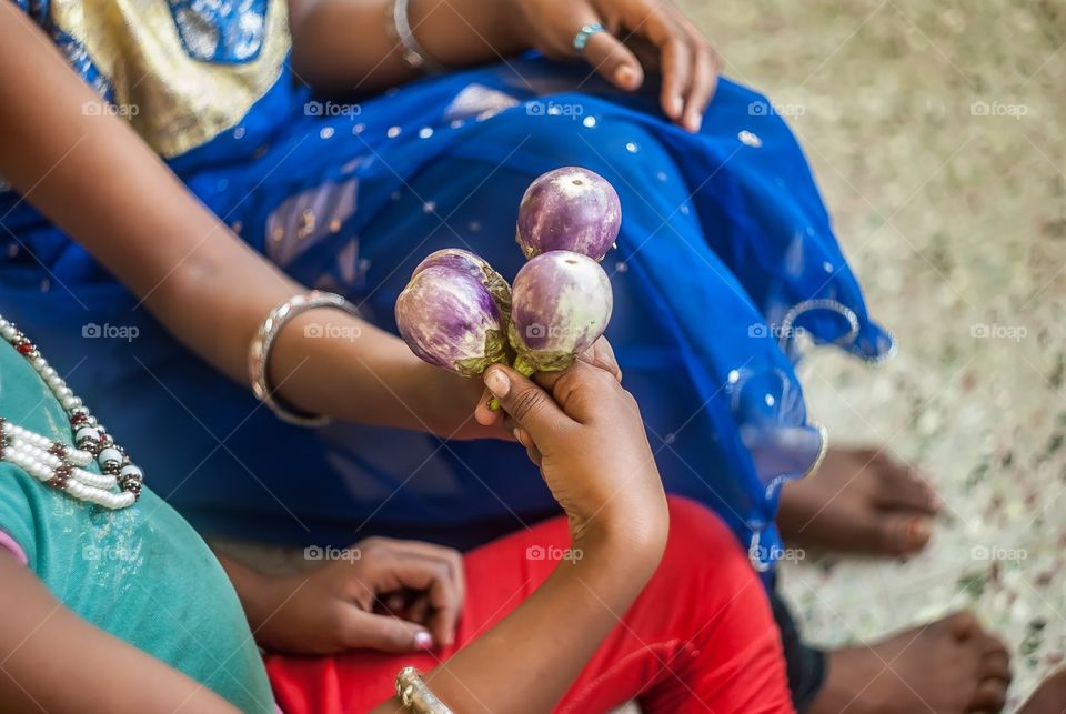 Girls holding brinjal
