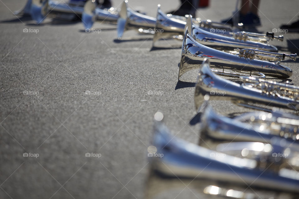 Marching band horns on blacktop. 