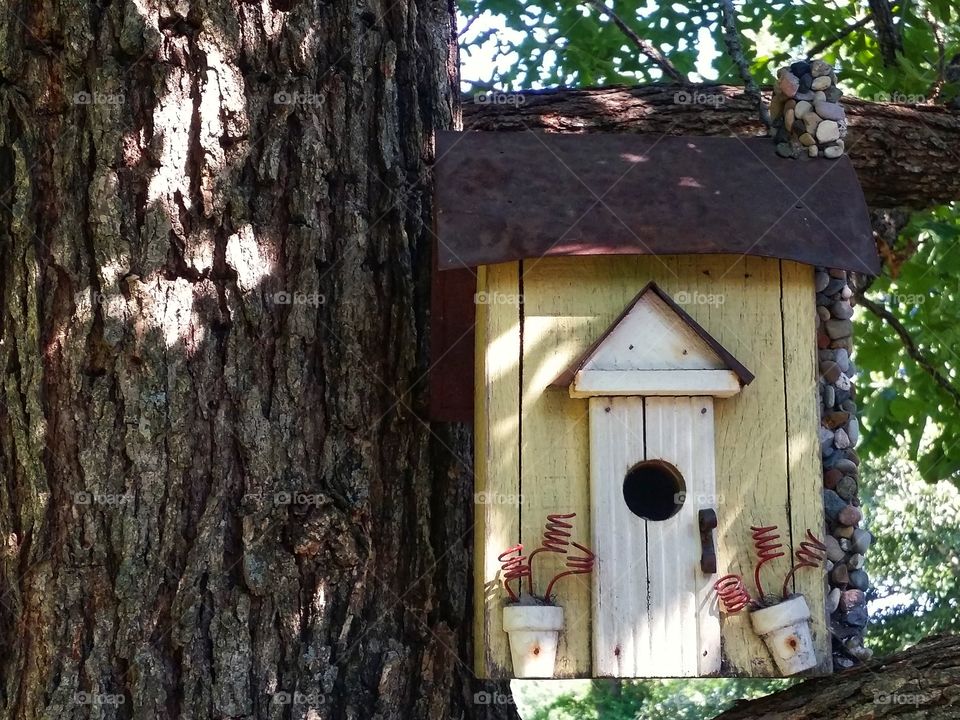 A birdhouse in a tree made out of reclaimed wood and rusty tin zero waste recycle