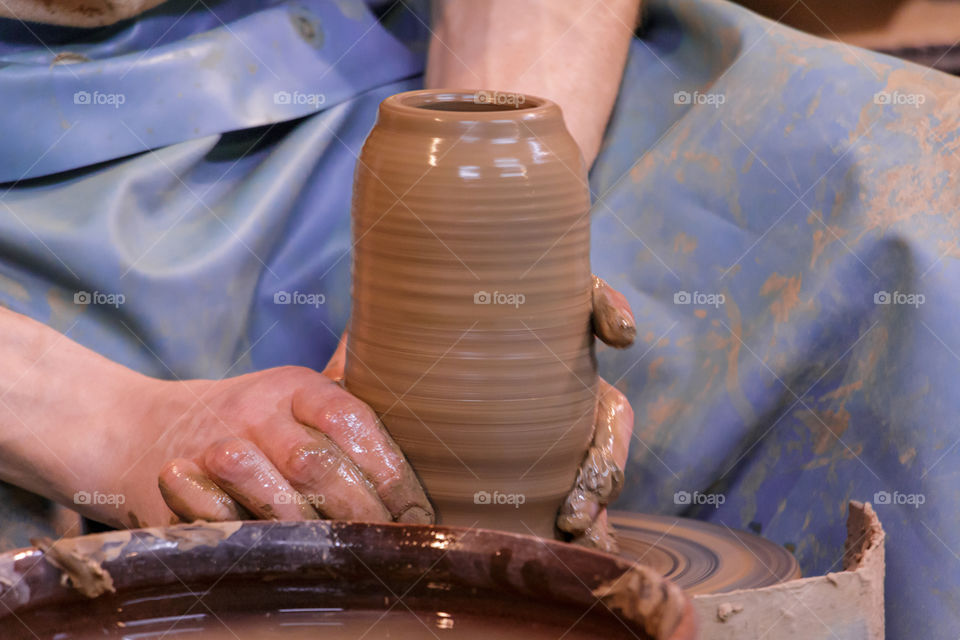 Learning pottery - man making a pot of clay