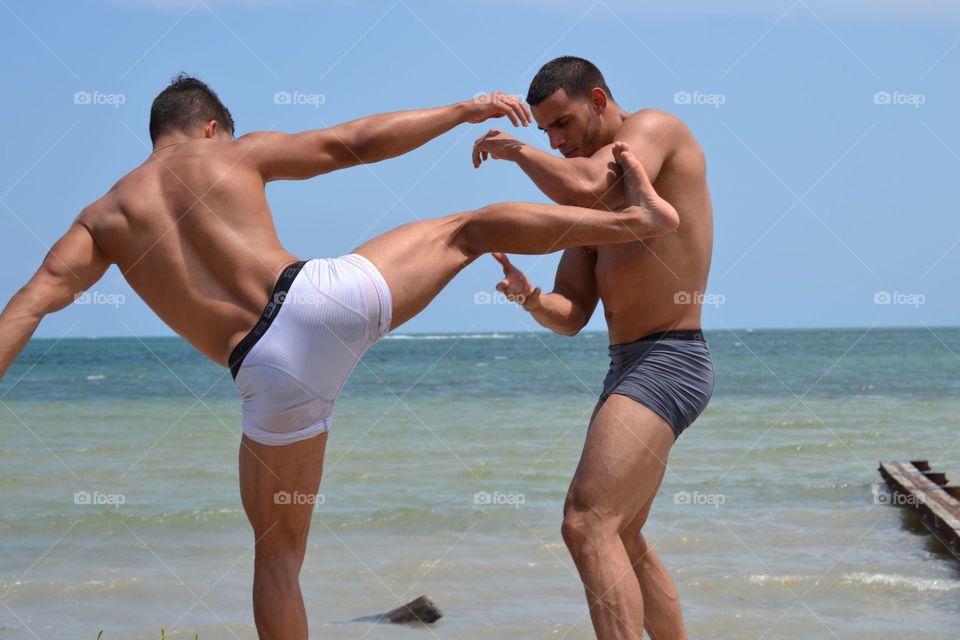 Two men fighting on beach