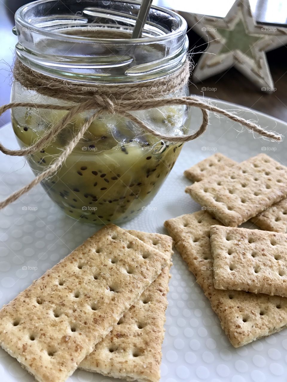 Homemade Kiwi jam and crackers on a plate 