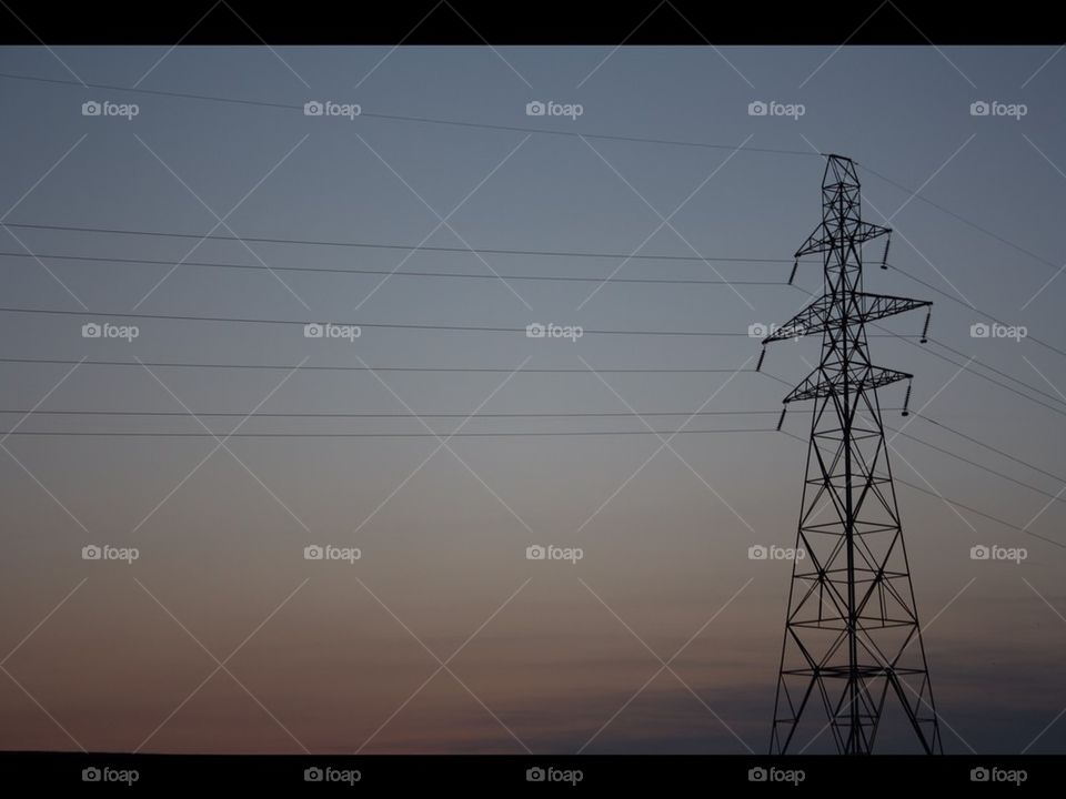 electricity pylon in front of a sunset 