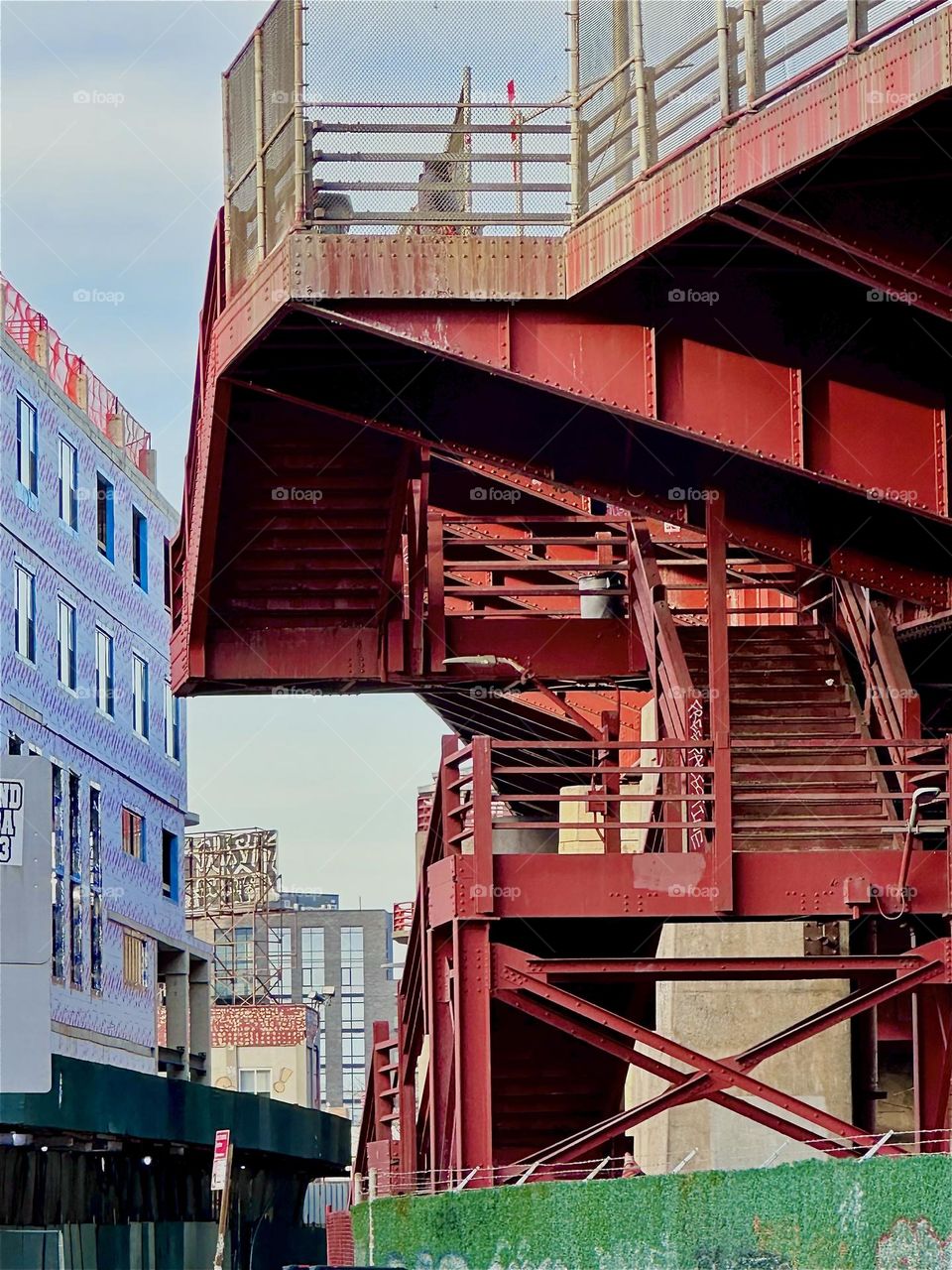 This is the utopian looking red metal staircase of the „Pulaski Bridge“ at „Newtown Creek“ in „Greenpoint“, Brooklyn. The industrial minimalist building style reminds of the „Bauhaus“ art and design school from the 1930s. 2024. Hypnotic Productions