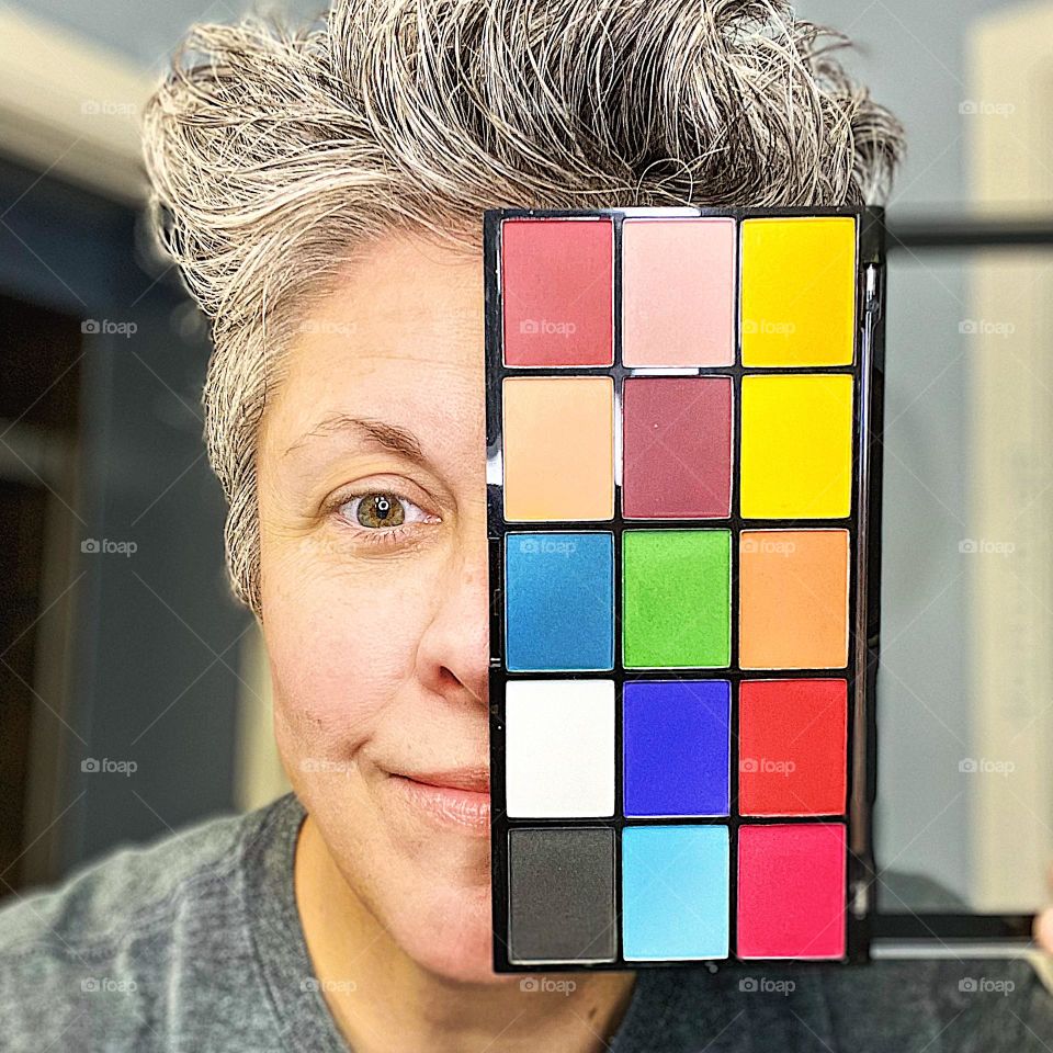 Woman with eye shadow, unique pose with eye shadow palette, colorful eye shadow makes a pop, woman and eye shadow, colors of the world, bright colors of makeup