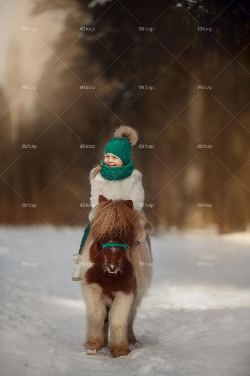 Little girl with pony at early spring day