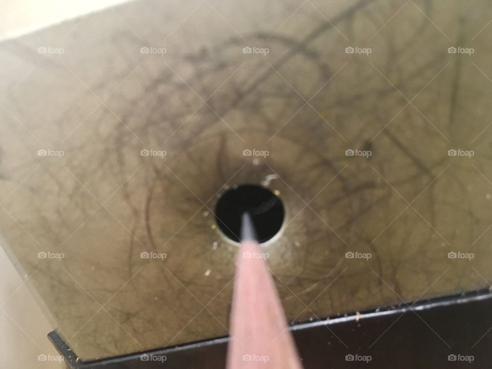 Pencil point coming out of an old, electric sharpener.  