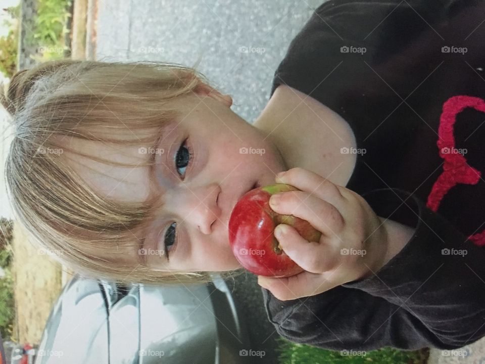 Little girl with Down syndrome with an apple