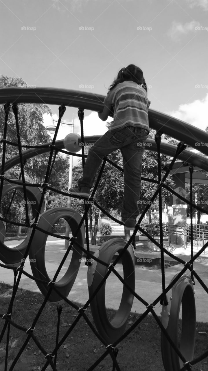 Girl climbing a Web at a playground