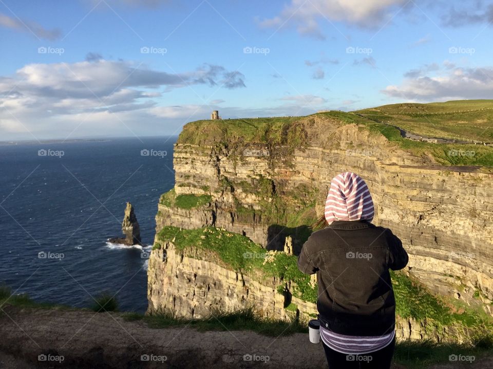 Person standing in front of the Cliffs of Moher, Ireland