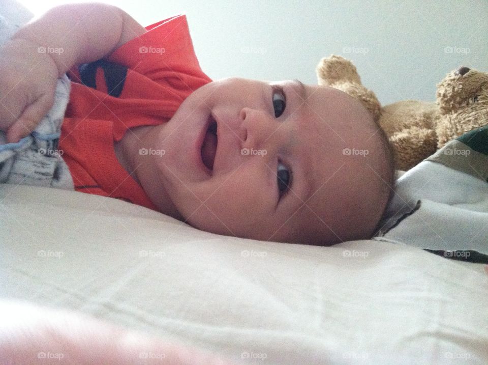 Smiling baby. 3 month old smiling in bed