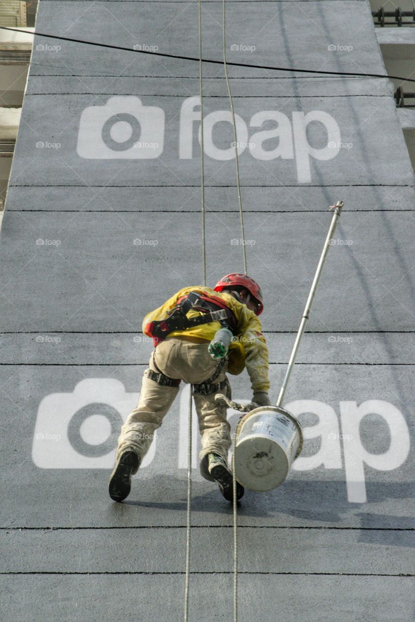painter abseiling down side of building appearing to pain the foam logo