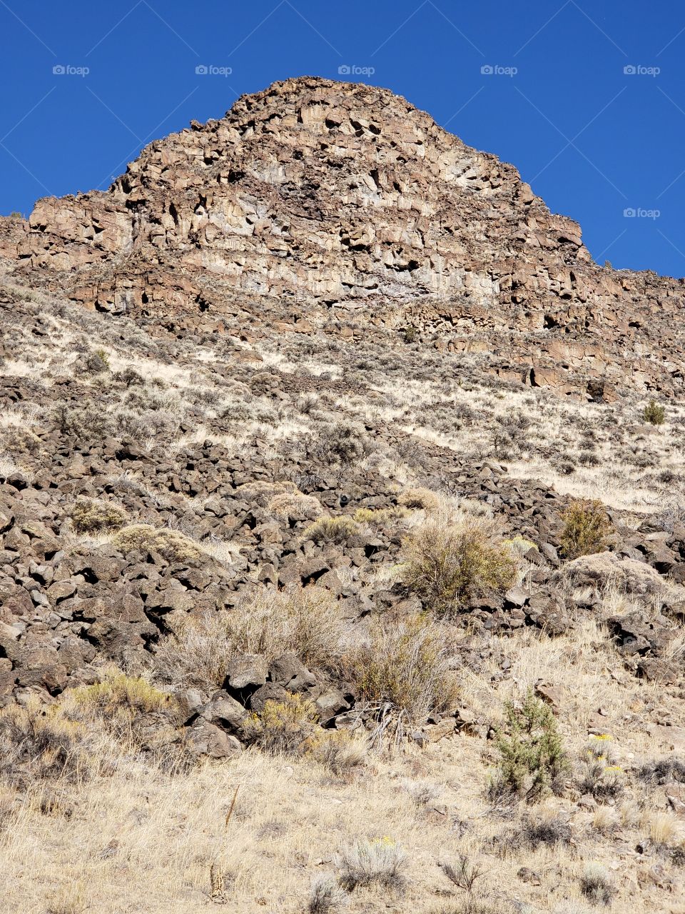 Hills along the Crooked River Highway made from andesite and basalt flows on a sunny fall day with clear blue skies in Central Oregon. 