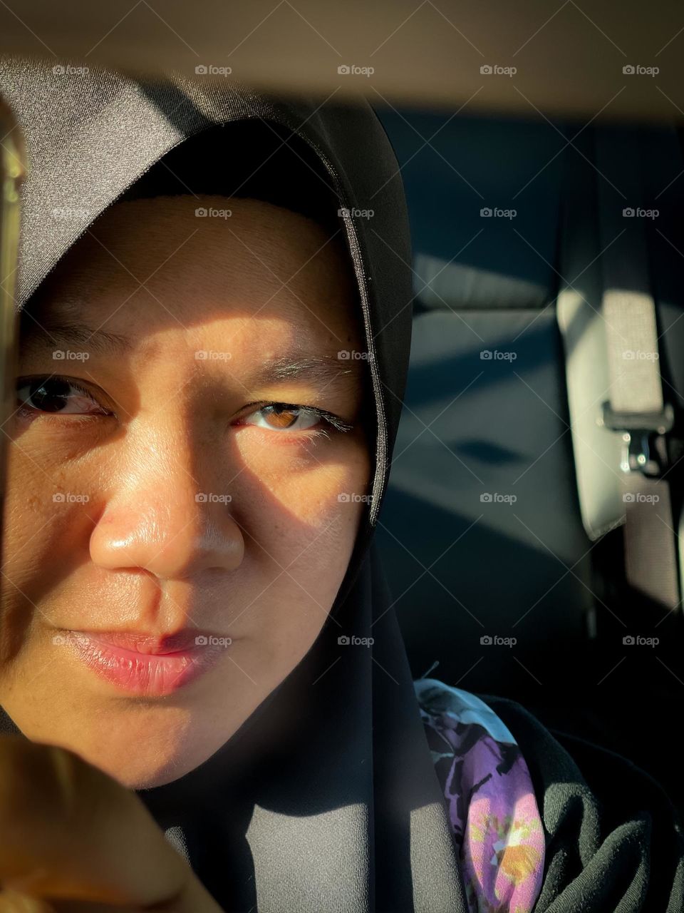 Reflection of self in a car using a smartphone with beautiful sun rays 