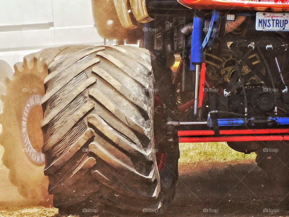 American Monster Truck. Giant Tire Of A Monster Truck Churning Dirt
