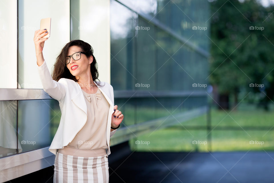 Businesswoman taking selfie with smartphone