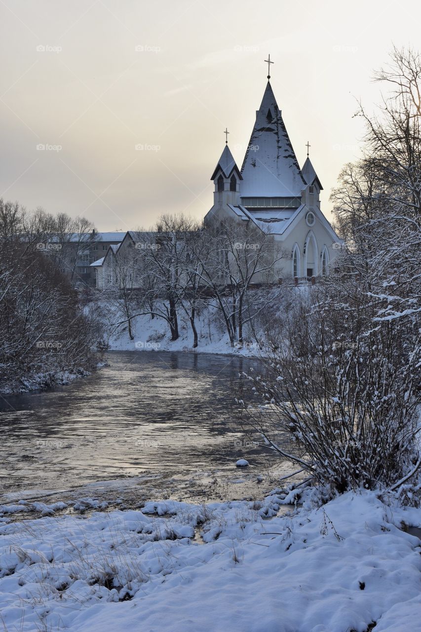 Католический костёл на берегу реки одним зимним, морозным днём.