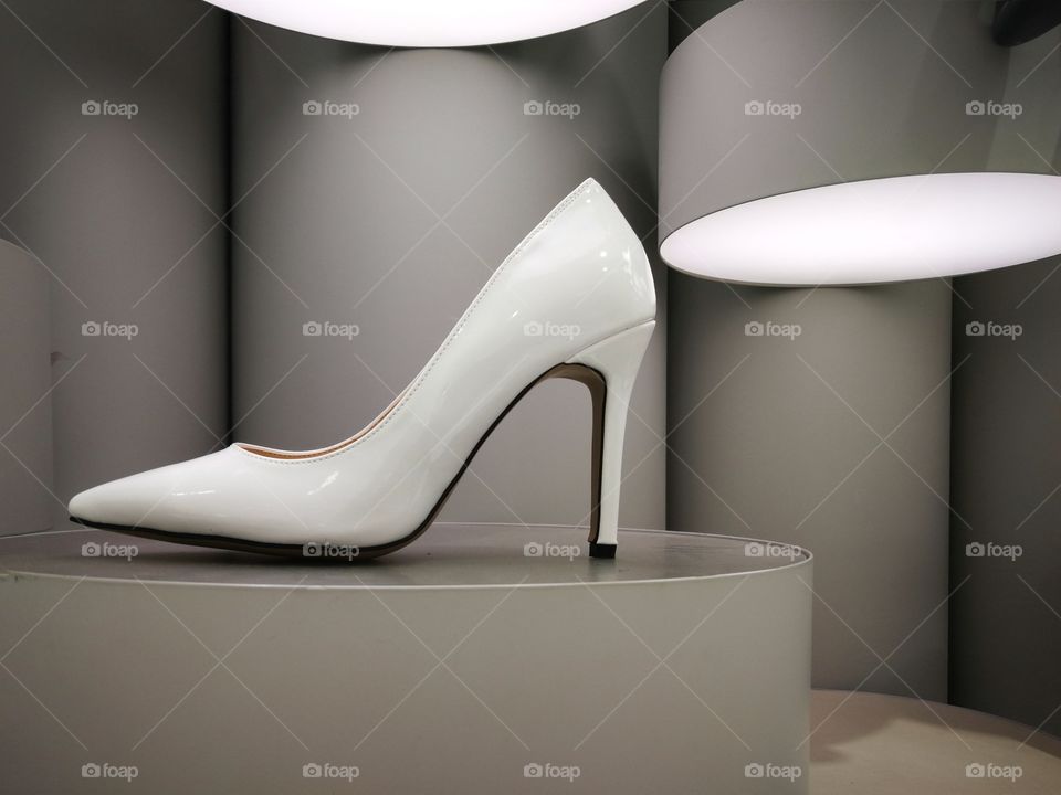 Classy white high gloss high heel on futuristic display