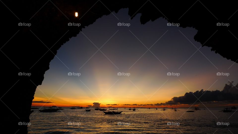 Boat on calm sea at sunset