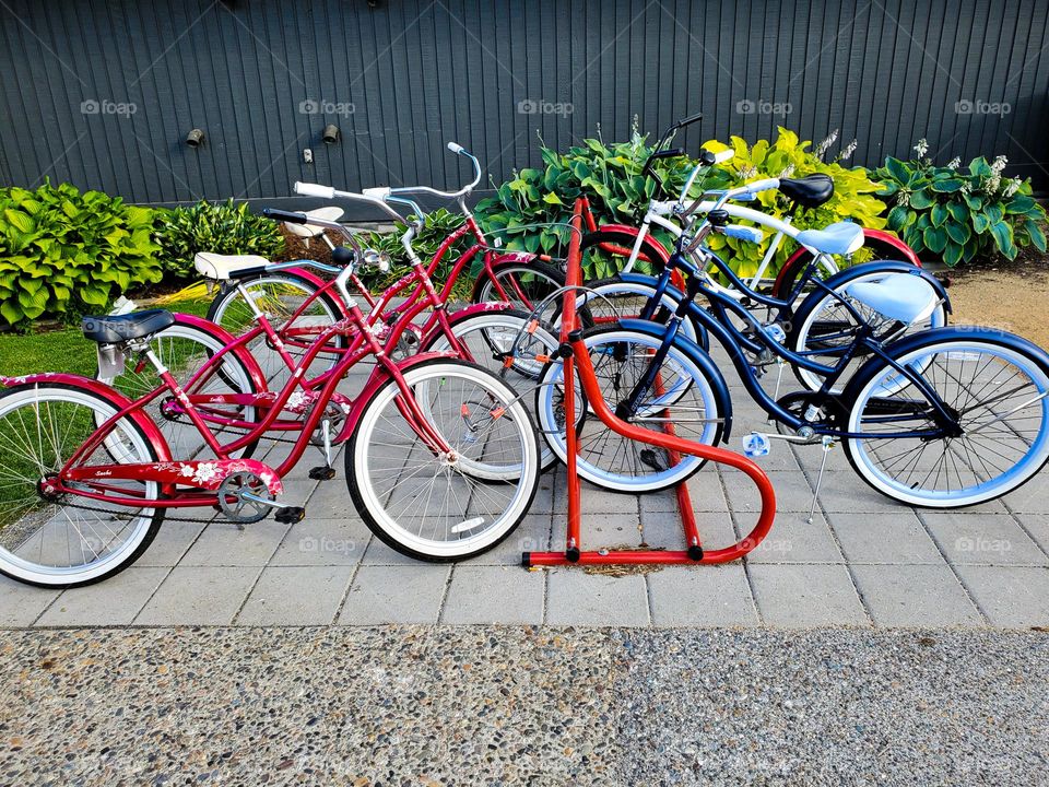 Bicycles sit in a rack awaiting their riders