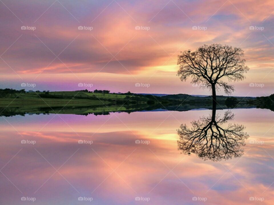 Dramatic sky reflecting on lake during sunset