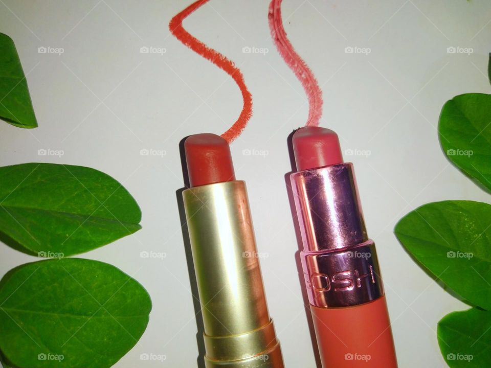 Lipsticks against a green and white background.