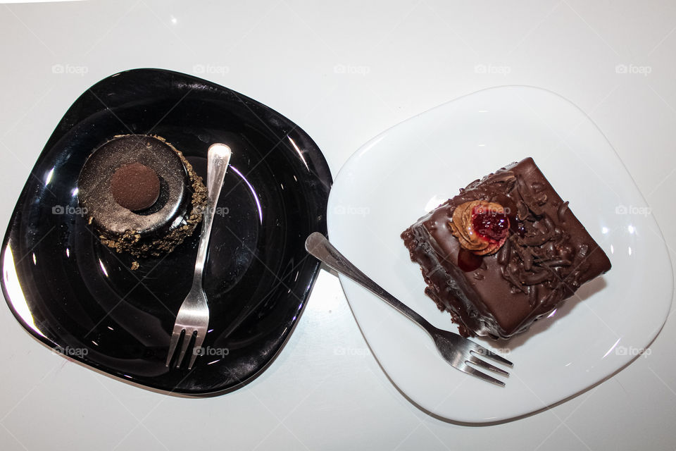 Chocolate cake with walnuts and chocolate mousse with raspberries and the white and black plates