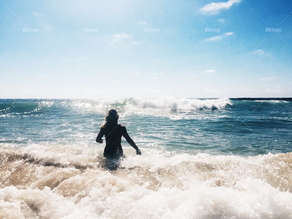 Female running into ocean