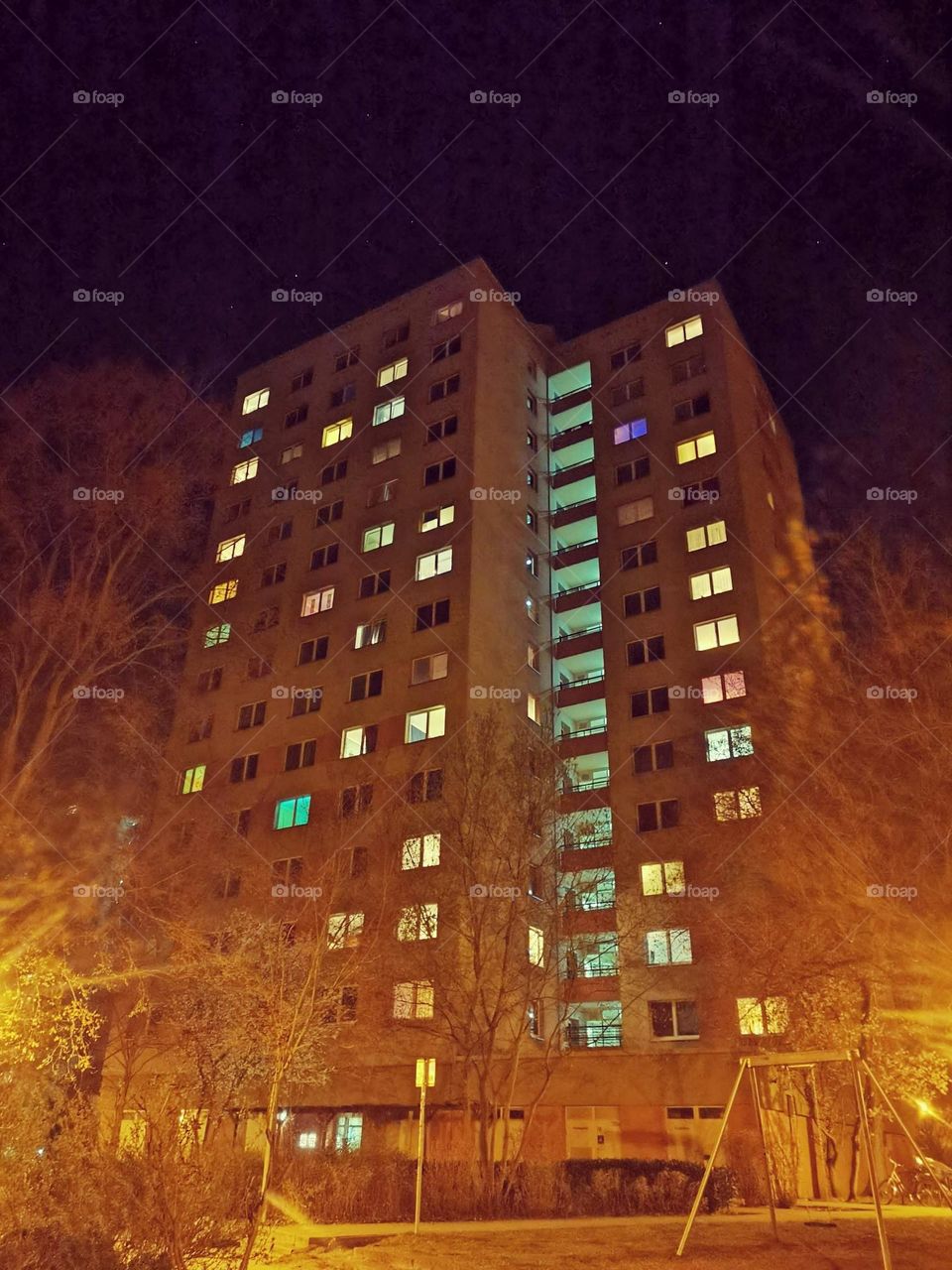 A high-rise building at the evening with lightened windows