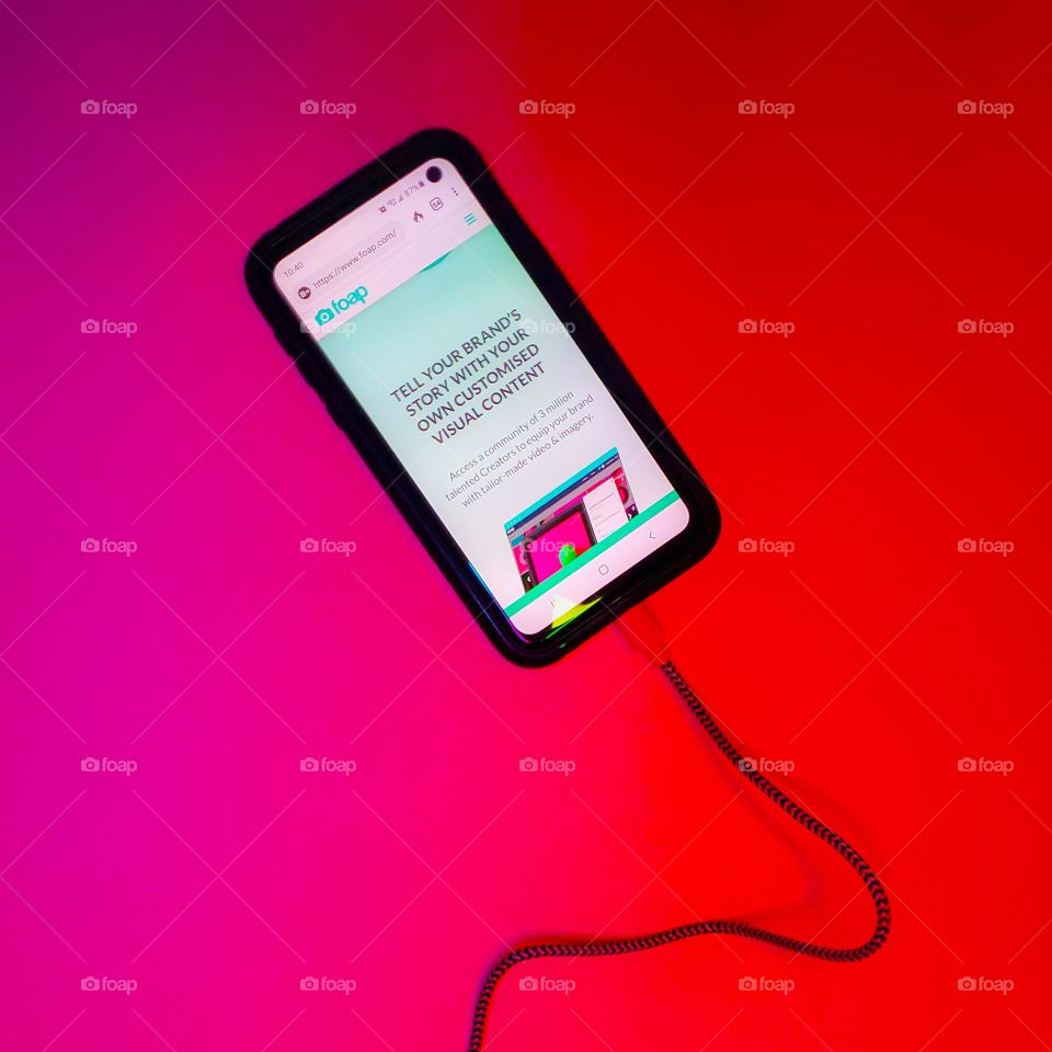 Red clashing with pink and a charging cell phone with the FOAP market home page.