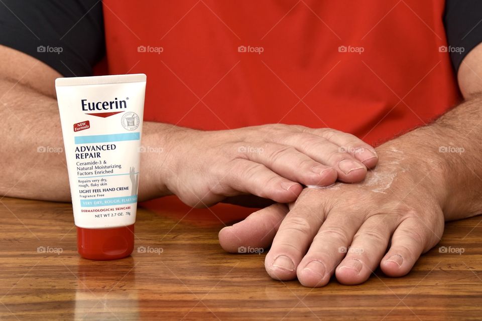 Man applying Eucerin hand cream to his hands