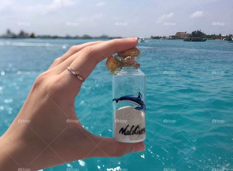 maldive sand in clear bottle and the sea