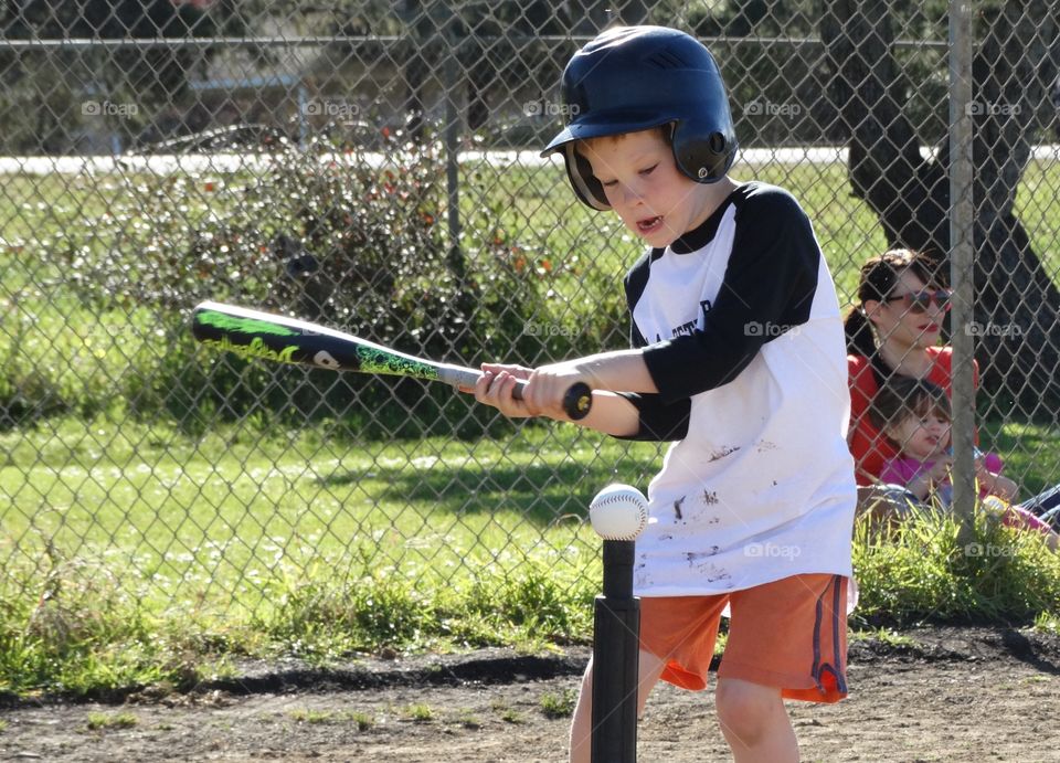 Batter Up!. Young boy taking a swing at T-ball