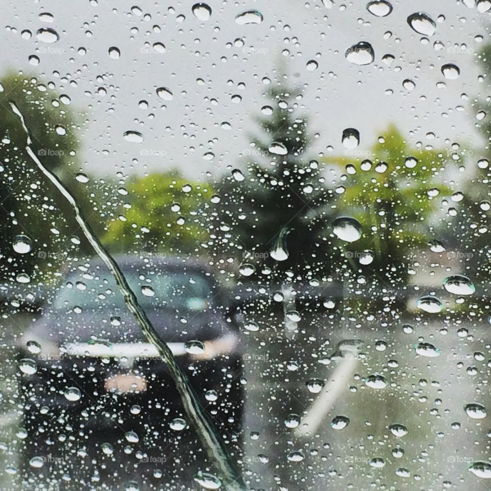 Car windshield speckled with rain drops