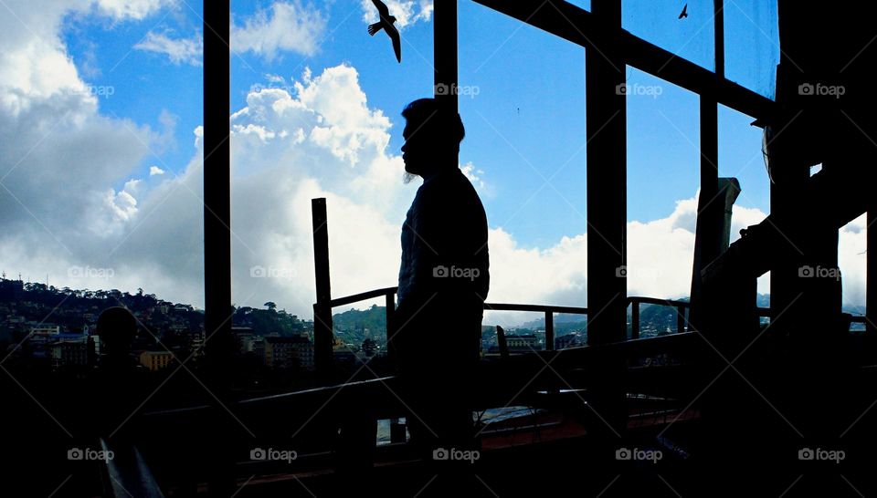 A man’s silhouette by the window