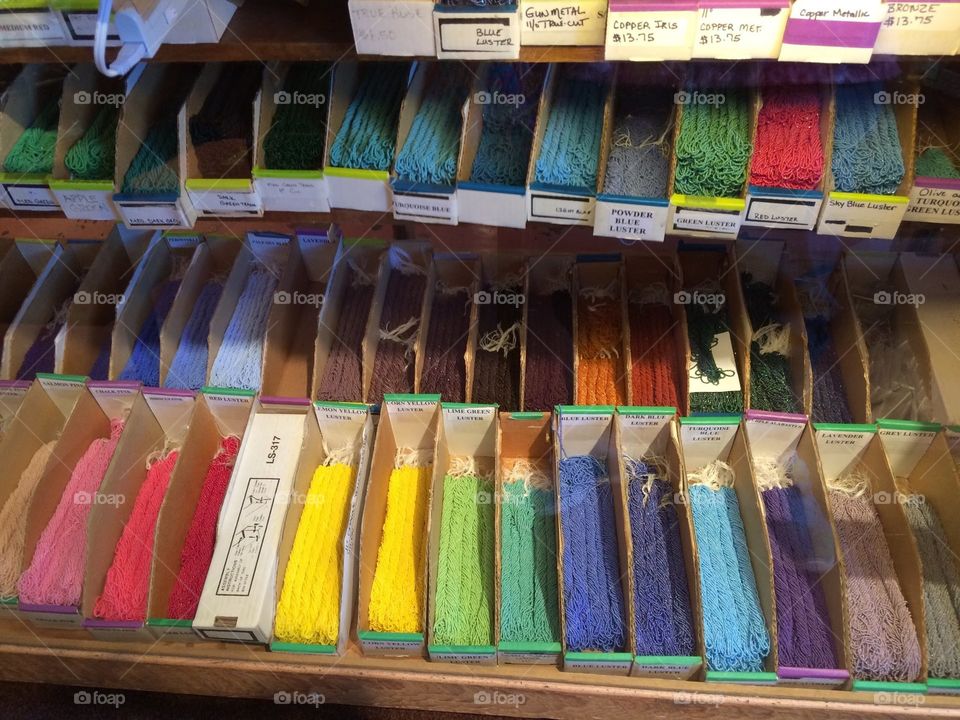 Variety of colorful beads on store display shelf 