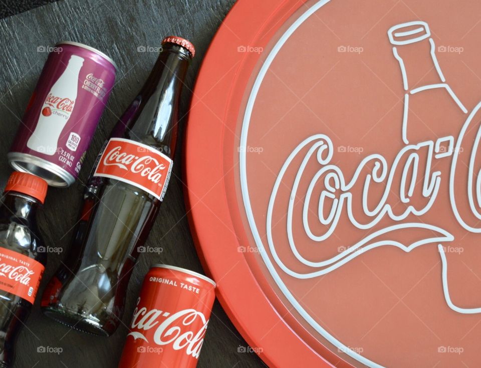 Coca-Cola flat lay with a can of Coca-Cola a can of cherry Coke on a black background