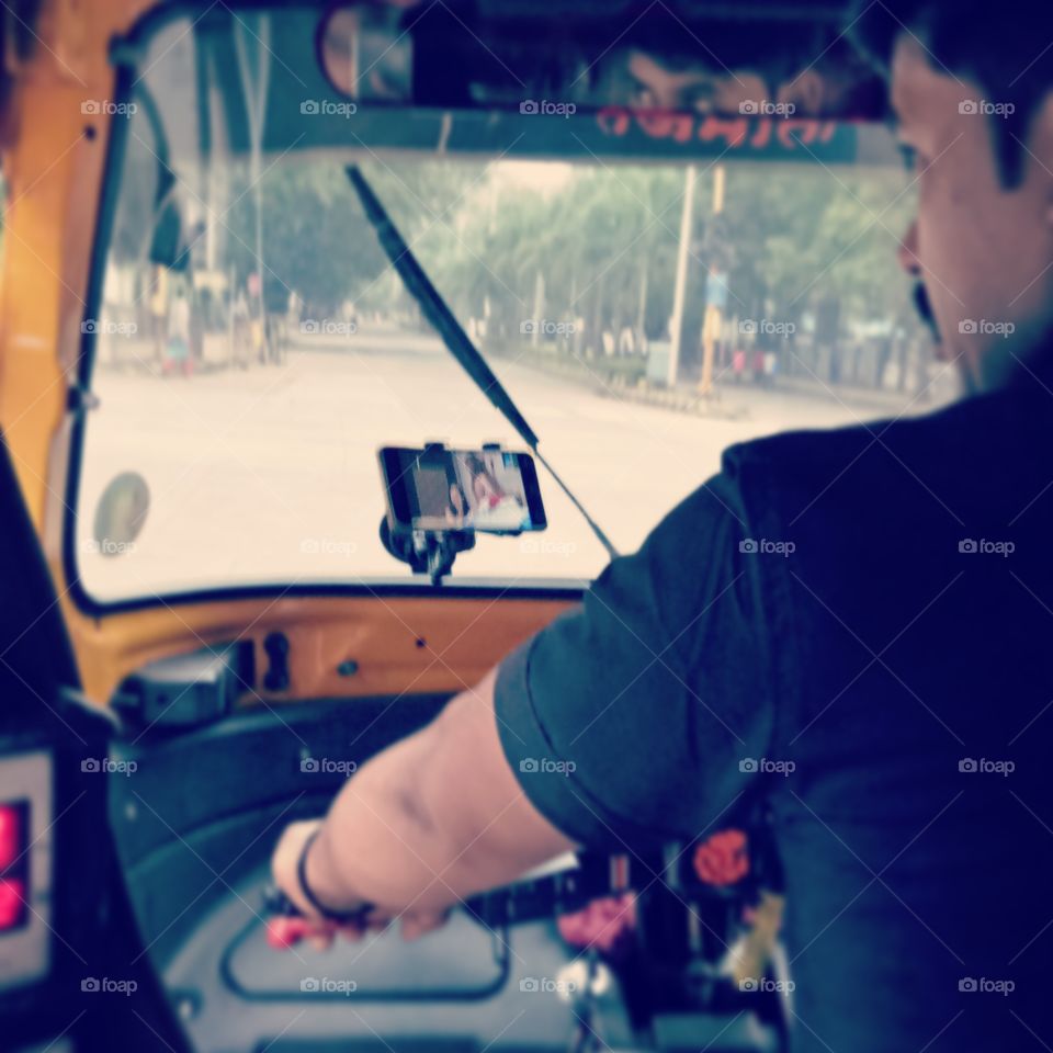 crazy auto driver  watching mobile tv while driving auto riksha in india mumbai belapur