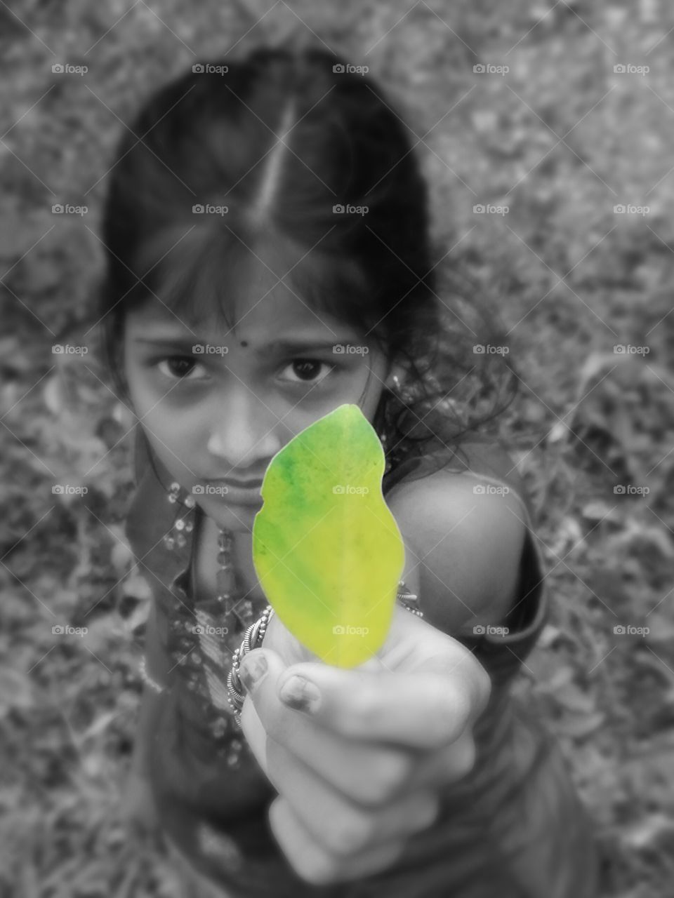 Little indian girl holding leaf in hand during autumn