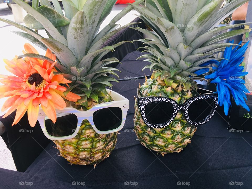 Pineapples with flowers and sunglasses 