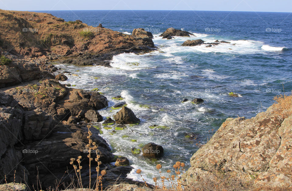 Colour coastal landscape with rocks and white foamy waves